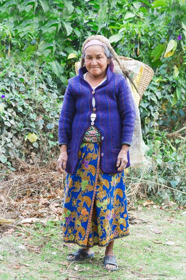 Old Nepalese woman carrying stones for road construction on her back