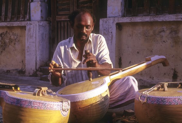 Man works at Veena instrument