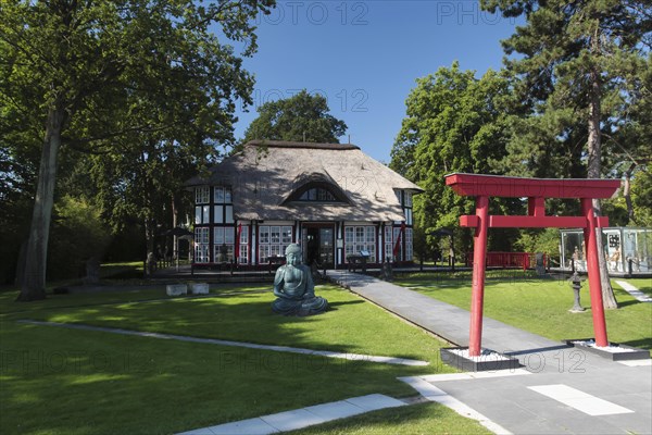 Thatched roof house Mikado Garden with Buddha rope