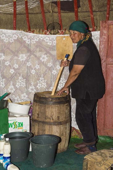 Kyrgyz woman mixing kumis during the fermentation process