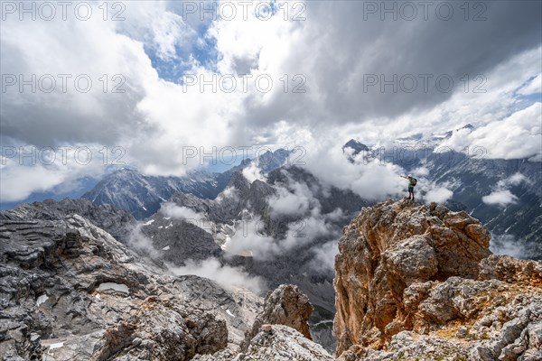 Hiker standing on a rock and pointing into the distance