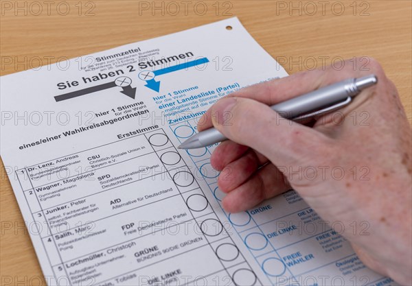 Hand with biros over ballot paper for the election of members of the German Bundestag on 26.09.2021