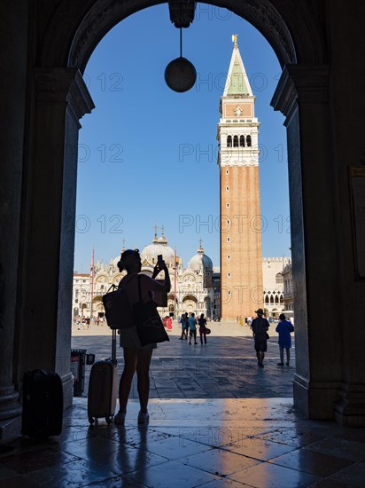 Silhouette of a tourist taking pictures with her mobile phone