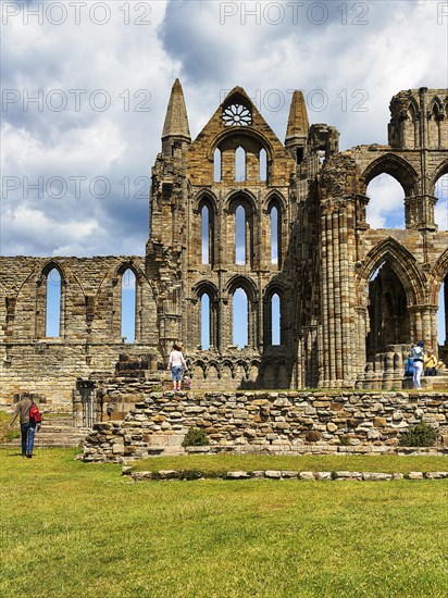 Ruin of the Gothic monastery Whitby Abbey with visitors