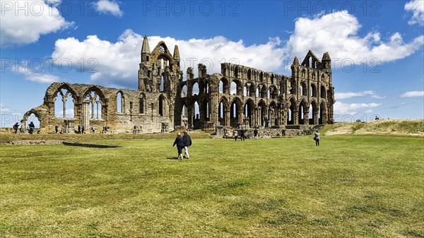 Ruin of the Gothic monastery Whitby Abbey with visitors