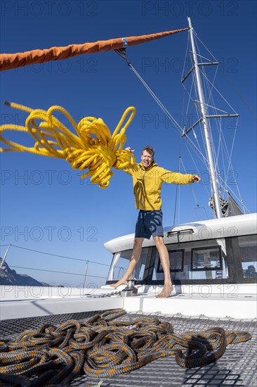 Sailor throws a yellow rope towards the camera