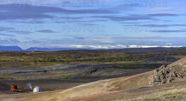 Geothermal plant and snow-capped mountains in the west