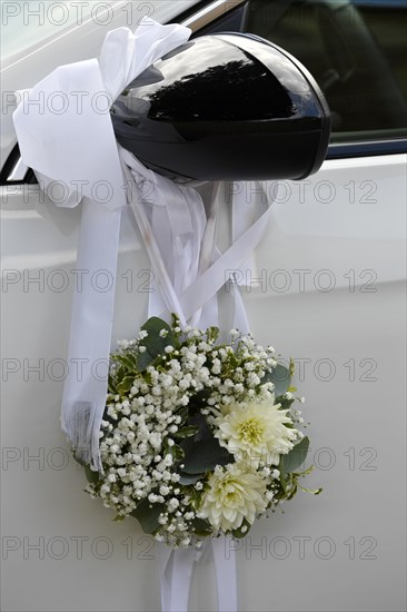 Wedding decoration on the wing mirror of a car