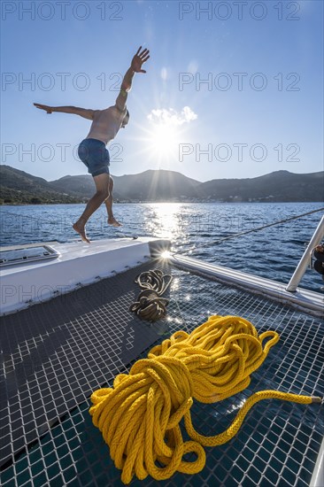 Young man jumps into the water