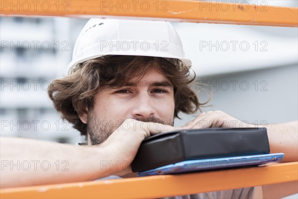 Technician with beard middle aged and working outside with polo shirt and helmet