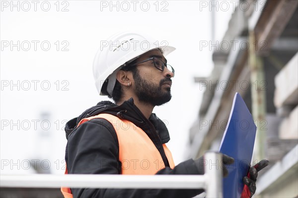 Technician with beard and helmet works in a workshop