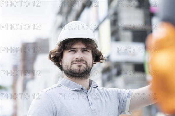 Technician with beard middle aged and working outside with polo shirt and helmet