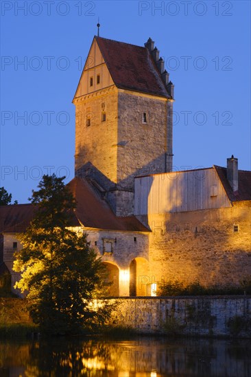 Illuminated Rothenburg Gate with city wall at the city pond