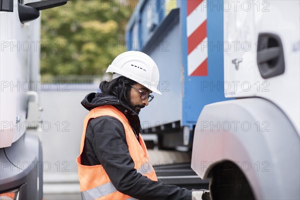 Technician with beard and helmet working on a truck