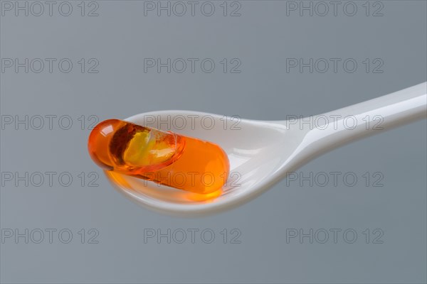 Capsule with omega-3 fatty acids in spoon