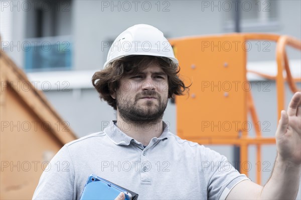 Technician with beard middle aged and working outside with polo shirt and helmet