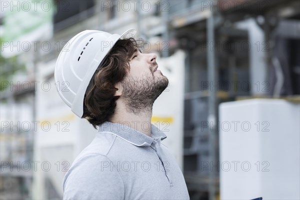 Technician with beard middle aged and working outside with polo shirt and helmet