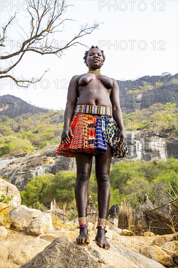 Traditional dressed young girls from the Laarim tribe standing on a rock