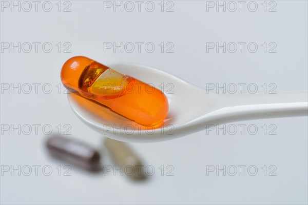 Capsule with omega-3 fatty acids in spoon