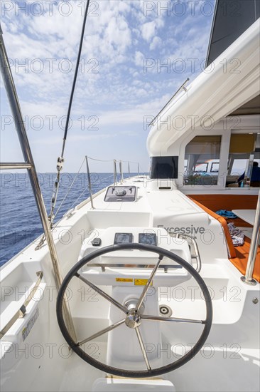 Steering wheel in the cockpit on the deck of a sailing catamaran