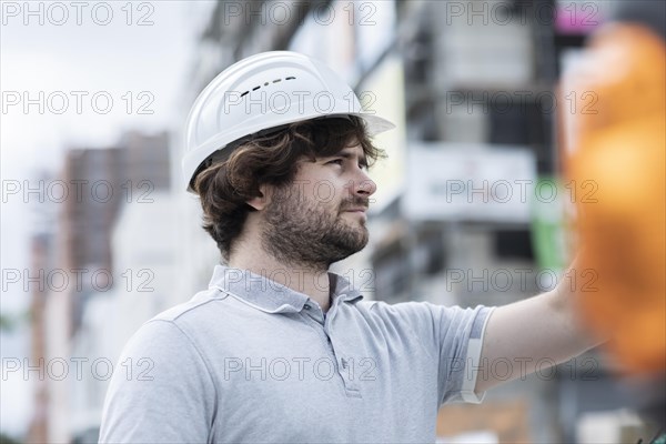 Technician with beard middle aged and working outside with polo shirt and helmet