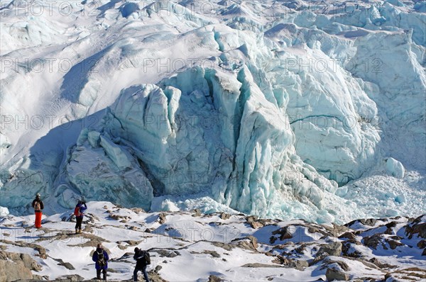 People in front of crevasses and ice front of a glacier