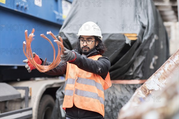Technician with beard and helmet working in a recycling yard
