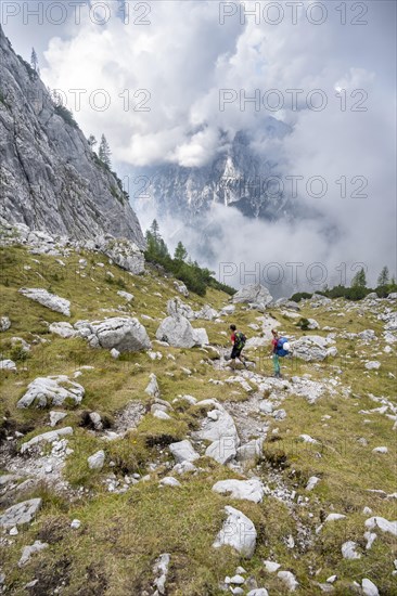 Two hikers descending through the Ofental valley