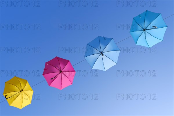 Coloured umbrellas against a blue sky