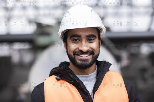 Technician with beard and helmet works in a workshop