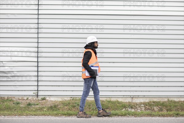 Technician with beard and helmet walking