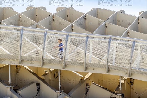 Small boy running on walkways of Setas de Sevilla