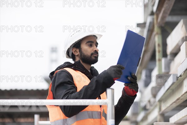 Technician with beard and helmet working in a recycling yard