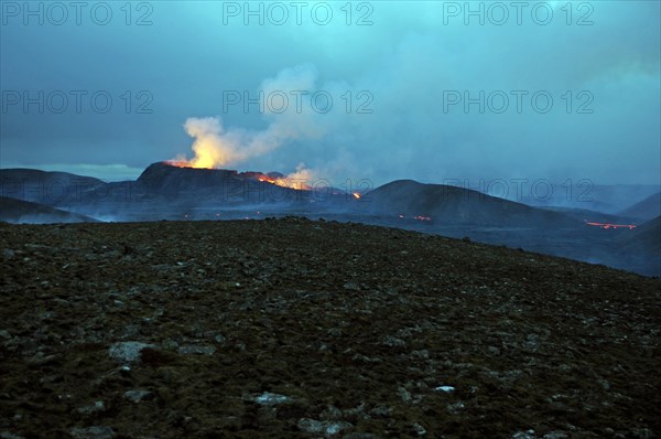 Stone desert and active volcano in the background