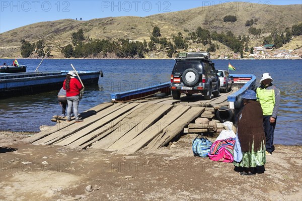 Austrian off-road vehicle on a simple ferry boat across the Strait of Tiquina