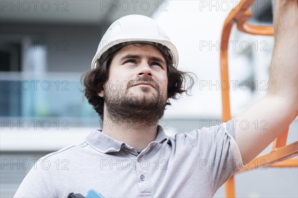 Technician with beard middle aged and working outside with polo shirt and helmet