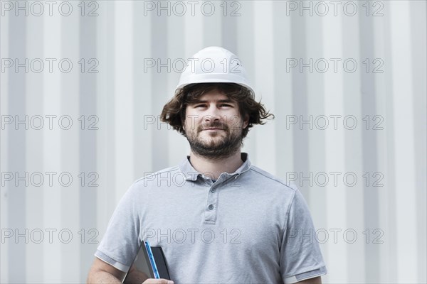 Technician with beard middle aged and working outside with polo shirt and helmet