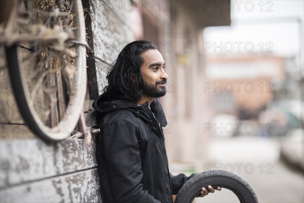 Young man with long hair at an old warehouse for tyres