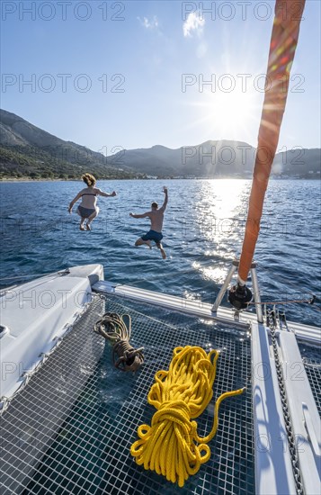 Young woman and young man jumping into the water