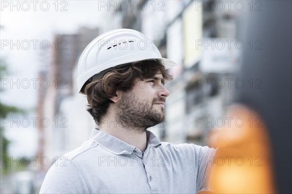 Technician with beard middle aged and working outside with polo shirt and helmet