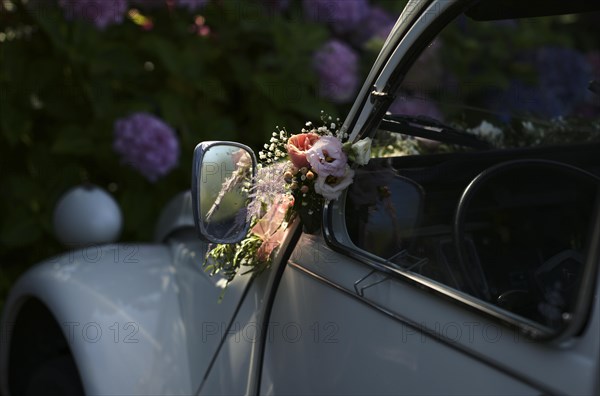 Wedding decoration on the wing mirror of a car