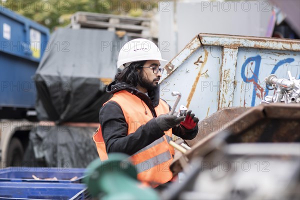 Technician with beard and helmet working in a recycling yard