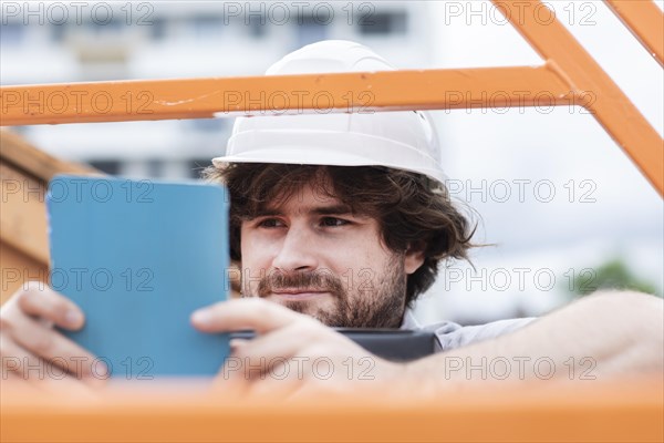 Technician with beard middle aged and working outside with polo shirt and helmet