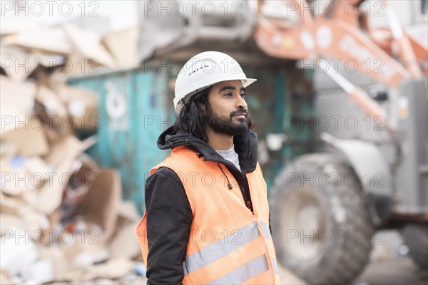 Technician with beard and helmet working in a recycling yard