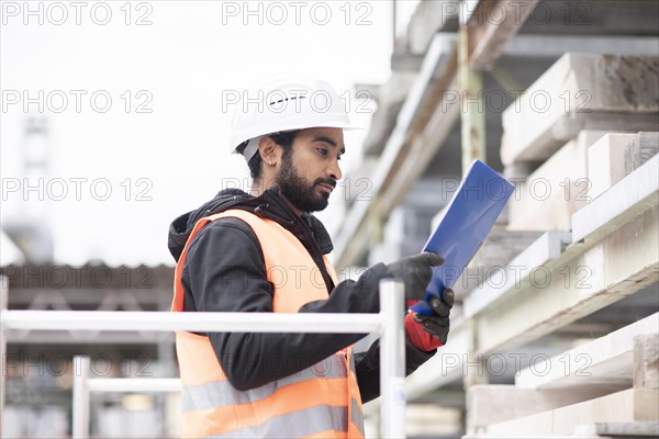 Technician with beard and helmet works in a workshop