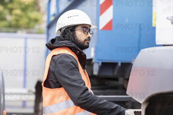 Technician with beard and helmet working on a truck