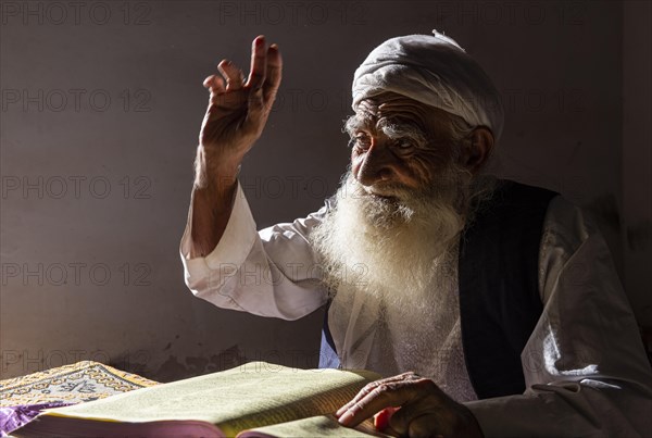 Sufi priest studying the holy Quran in the Shrine of Mawlana Abdur Rahman Jami