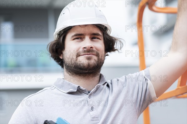 Technician with beard middle aged and working outside with polo shirt and helmet