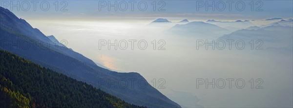 Lake Garda in the morning mist with Lake Garda mountains and Bergamo Alps