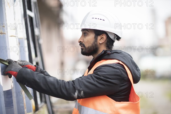Technician with beard and helmet works in a workshop